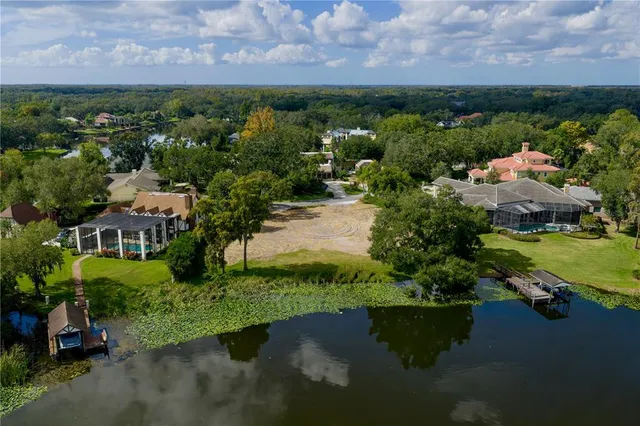 an aerial view of a house with a garden and lake view