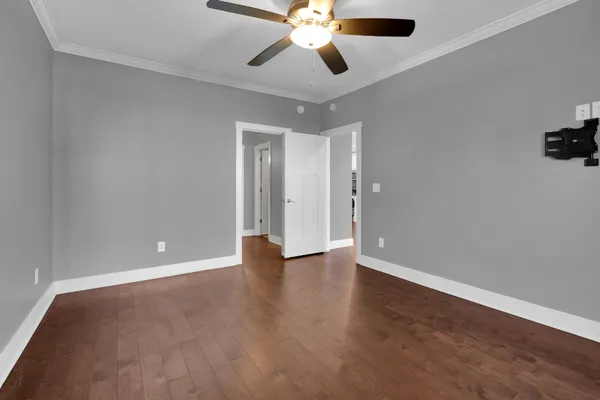 a view of an empty room with window and wooden floor