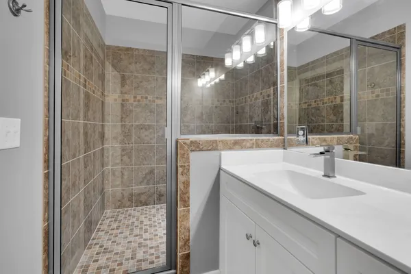 a bathroom with a sink a shower and a mirror