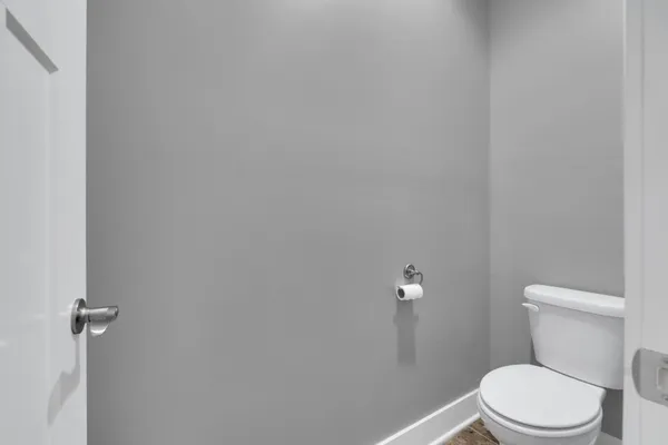 a white toilet sitting next to a shower
