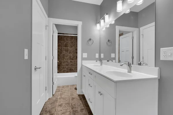 a bathroom with a double vanity sink and a mirror