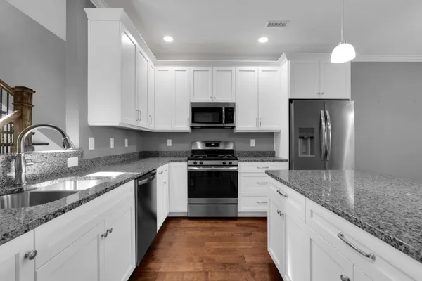 a kitchen with stainless steel appliances granite countertop a sink and a stove