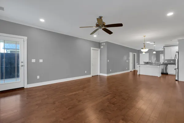 a view of empty room with wooden floor and windows