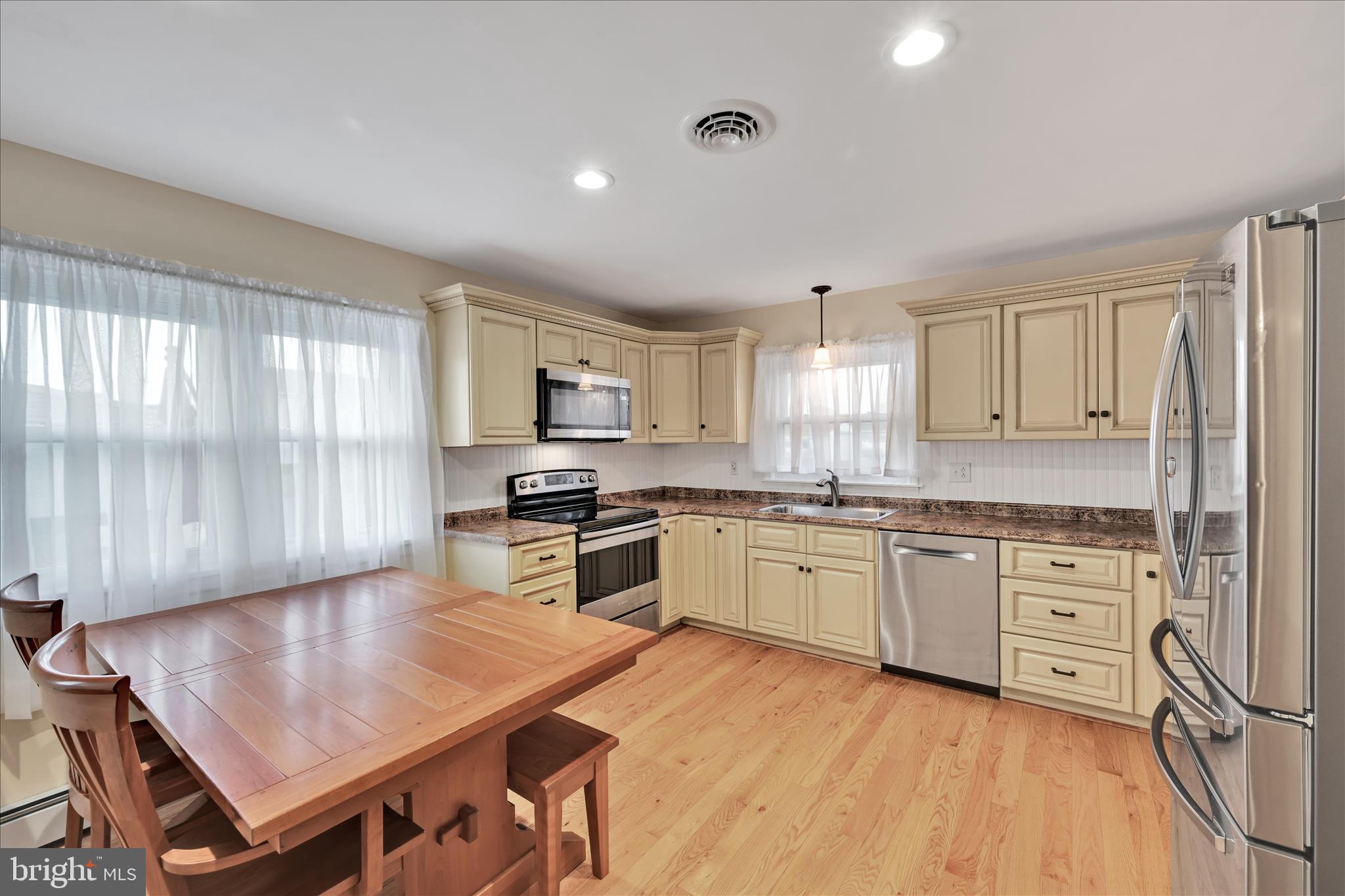 1931 South Forge Road Palmyra, PA 17078 - Photo 6 of 29 a kitchen with granite countertop a stove a sink dishwasher and a refrigerator with wooden floor