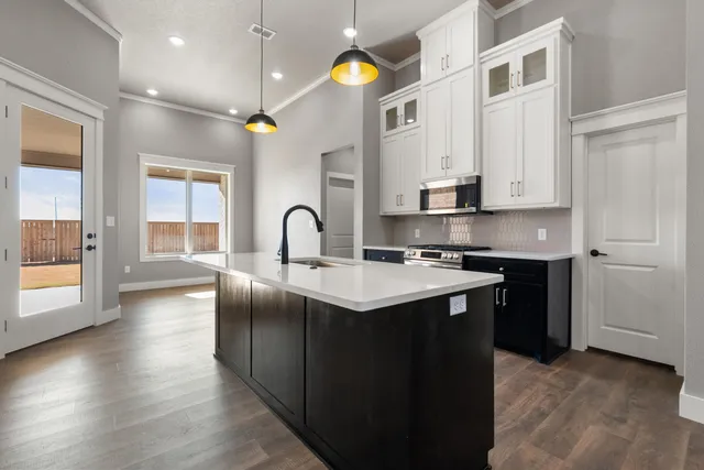 a kitchen with stainless steel appliances granite countertop a sink a stove and a refrigerator