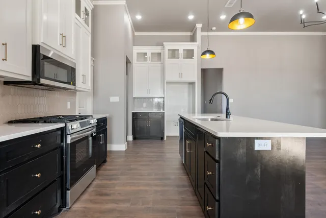 a kitchen with stainless steel appliances a sink stove and cabinets