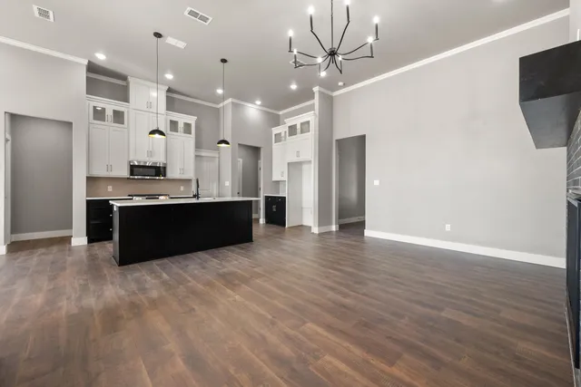 a large kitchen with stainless steel appliances a large counter top a refrigerator and a sink