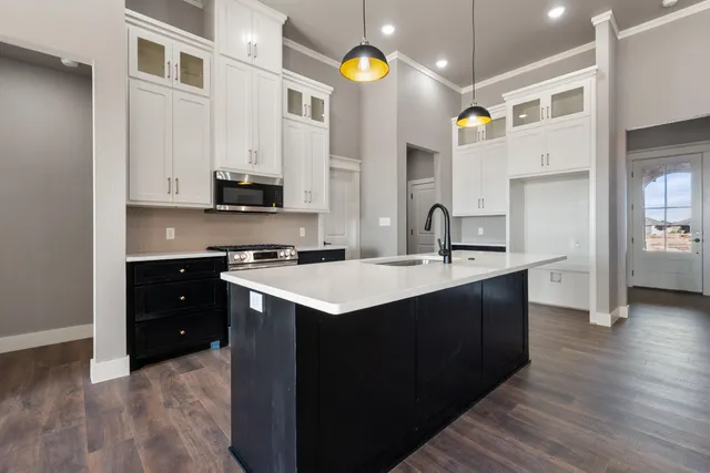 a kitchen with a sink cabinets and wooden floor