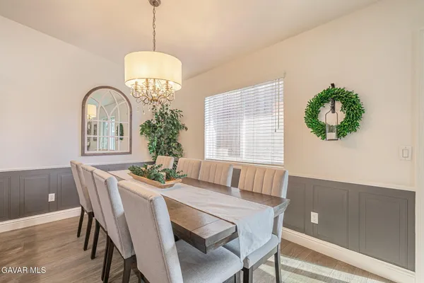 a kitchen with stainless steel appliances granite countertop a dining table chairs refrigerator and sink