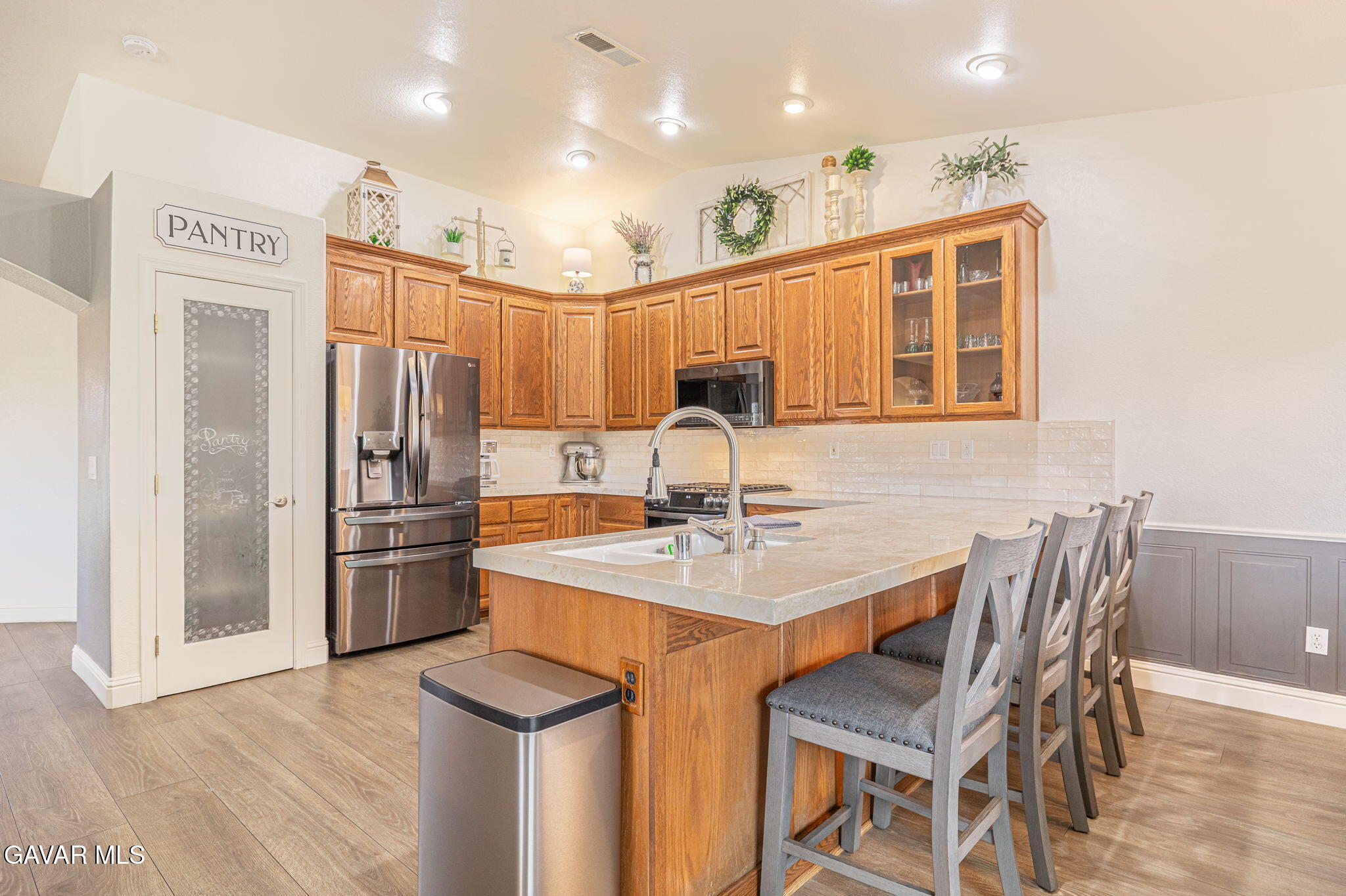 19812 Breeze Place Tehachapi, CA 93561 - Photo 18 of 59 a kitchen with stainless steel appliances granite countertop a dining table chairs refrigerator and sink