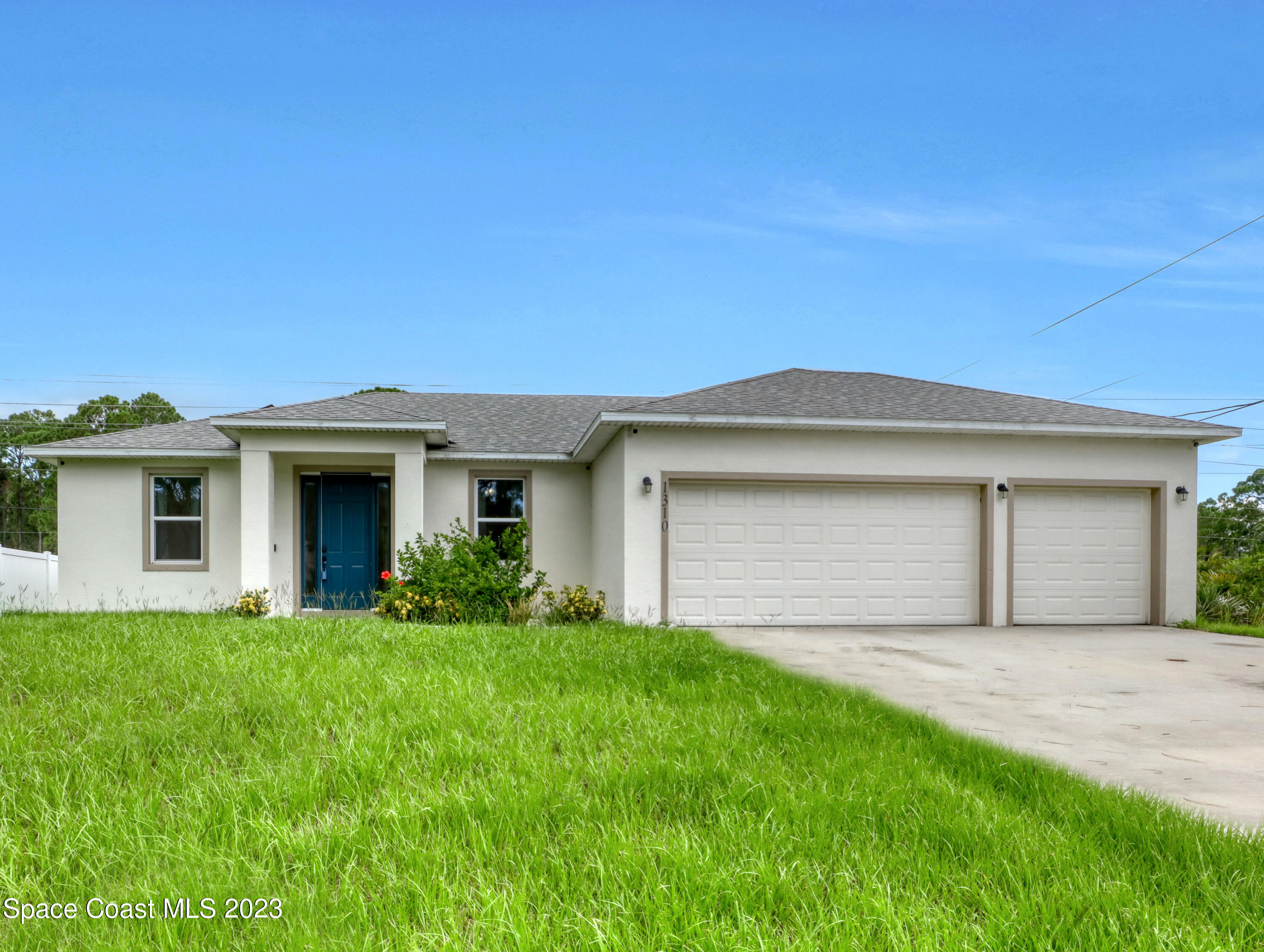1310 Gaucho Road Southwest Palm Bay, FL 32908 - Photo 1 of 32 a front view of a house with a yard and garage