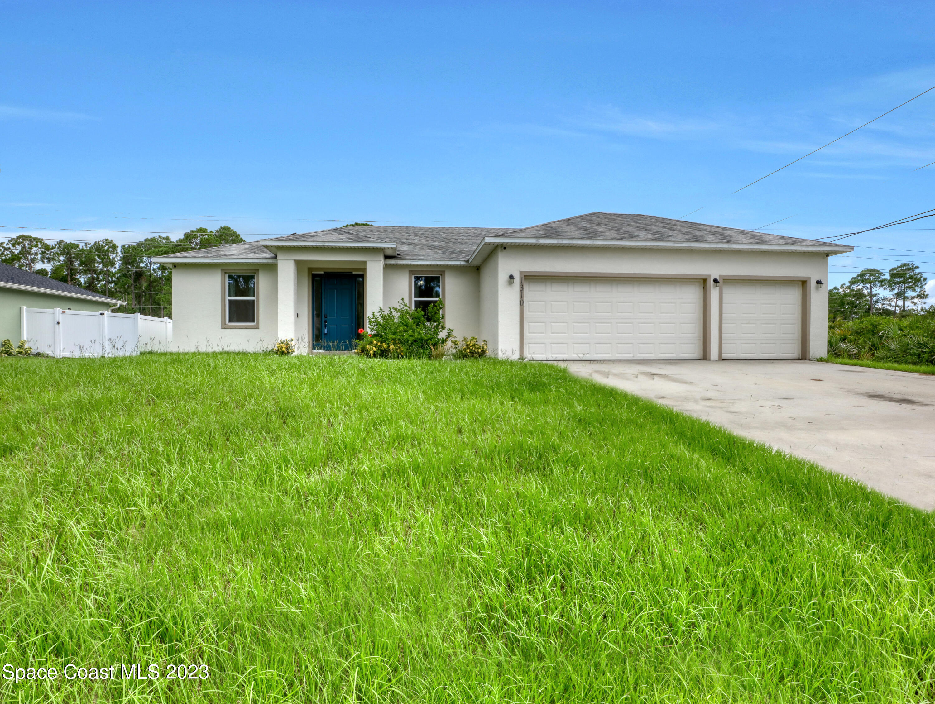 1310 Gaucho Road Southwest Palm Bay, FL 32908 - Photo 4 of 32 a front view of a house with a yard and garage