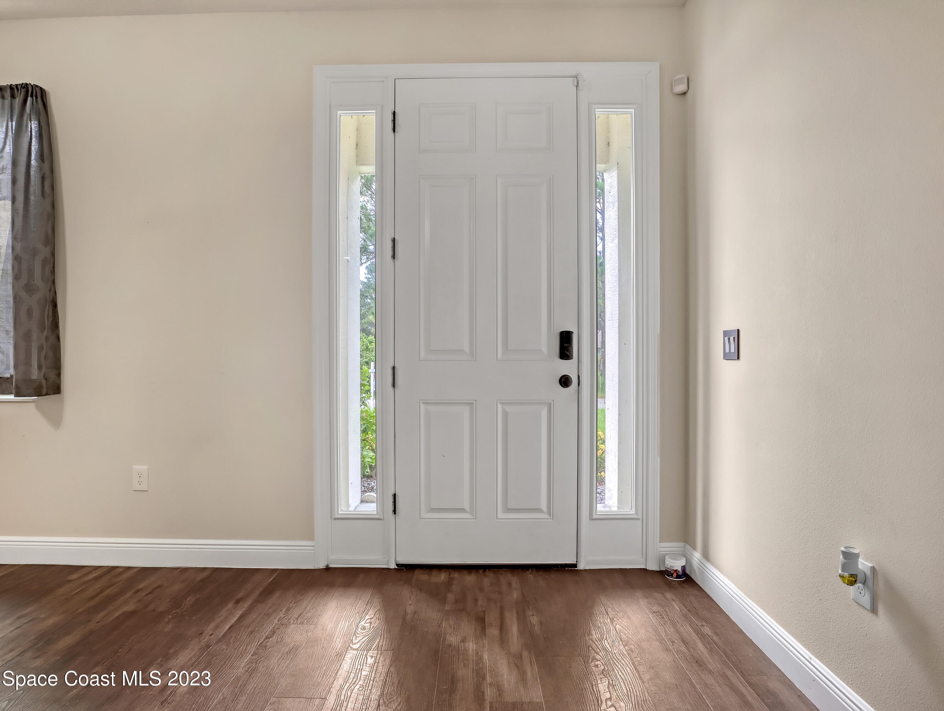 1310 Gaucho Road Southwest Palm Bay, FL 32908 - Photo 7 of 32 a view of an empty room with wooden floor and a window
