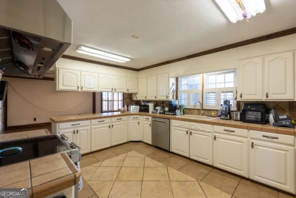 a kitchen with white cabinets and appliances