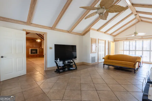 a living room with furniture a flat screen tv and a window
