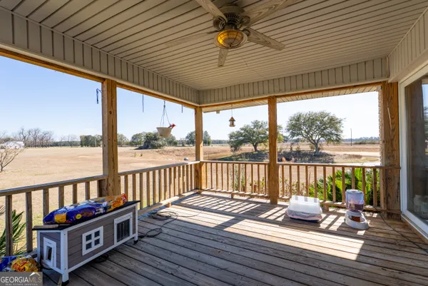 a view of a balcony with wooden floor next to a yard
