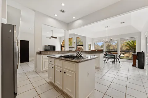 a kitchen with stainless steel appliances granite countertop a stove a sink and white cabinets
