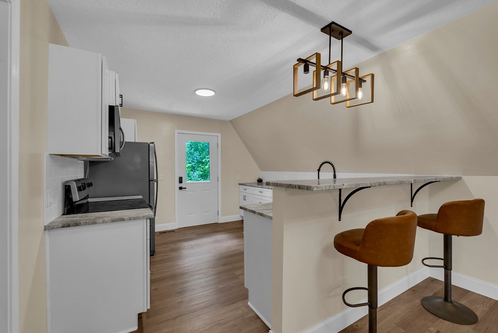 152 Parker Road Sparta, TN 38583 - Photo 4 of 30 a kitchen with stainless steel appliances granite countertop a sink a stove and a wooden floors
