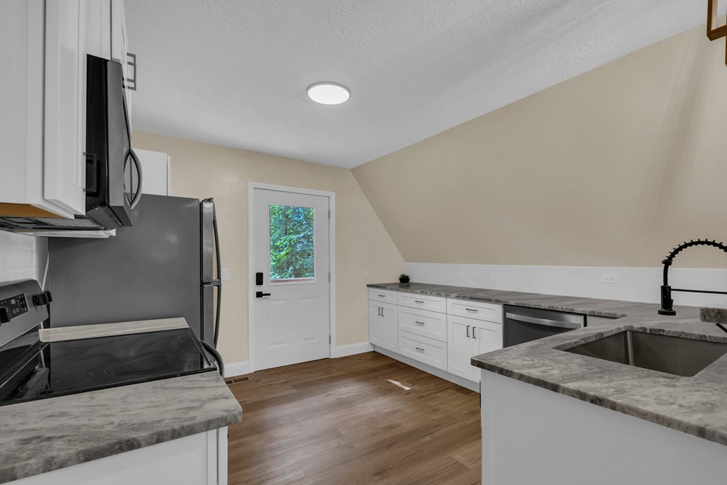 152 Parker Road Sparta, TN 38583 - Photo 6 of 30 a kitchen with granite countertop a sink and a stove top oven