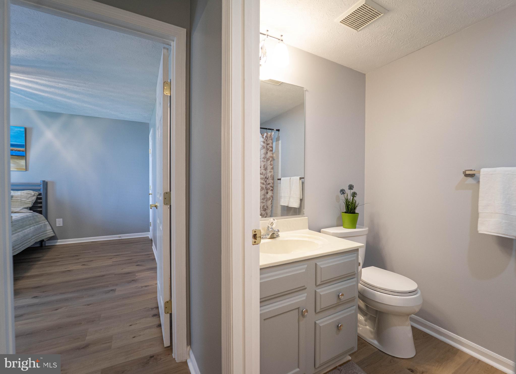 16 Laurel Path Court, Unit 1 Baltimore, MD 21236 - Photo 20 of 28 a bathroom with a granite countertop toilet a sink and a mirror