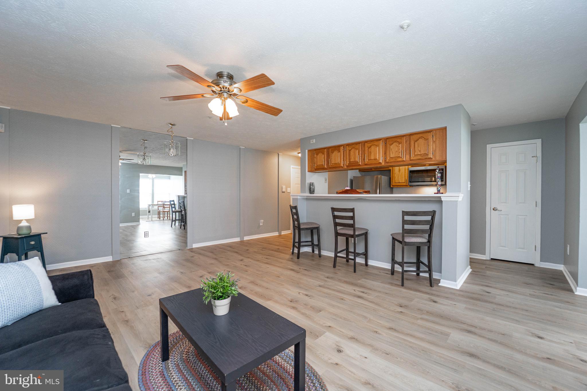 16 Laurel Path Court, Unit 1 Baltimore, MD 21236 - Photo 9 of 28 a living room with furniture and a dining table with kitchen view
