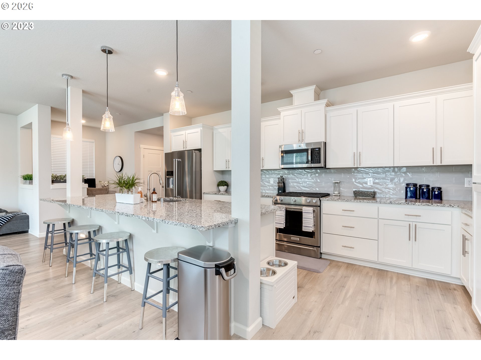6150 North 86th Avenue Camas, WA 98607 - Photo 13 of 41 a kitchen with stainless steel appliances granite countertop a stove a sink a refrigerator and white cabinets with wooden floor