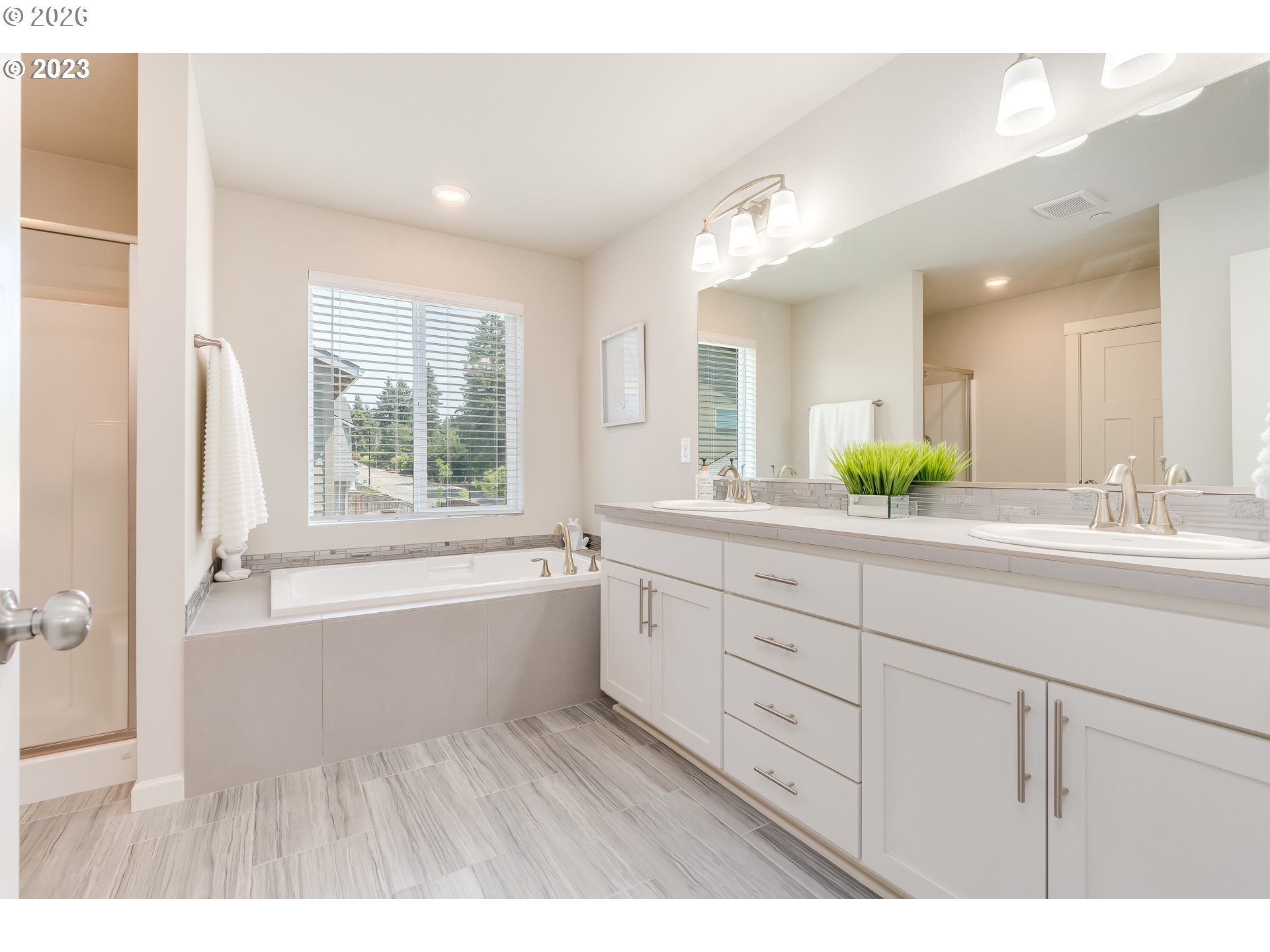 6150 North 86th Avenue Camas, WA 98607 - Photo 32 of 41 a spacious bathroom with double vanity a mirror a bathtub and a shower