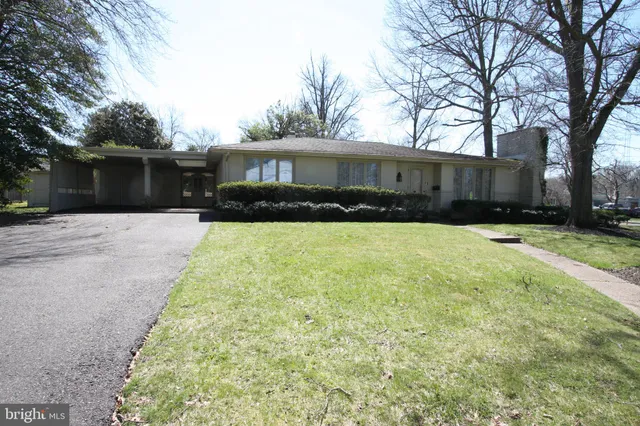 a front view of a house with yard and tree