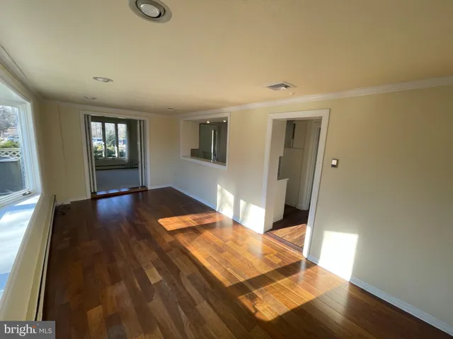 a bedroom with wooden floor and windows