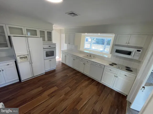 a kitchen with white cabinets and white appliances