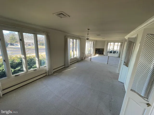 a view of a big room with windows and chandelier