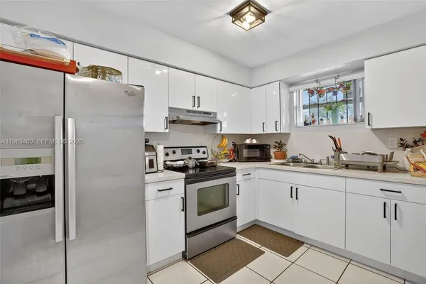 a kitchen with stainless steel appliances granite countertop a refrigerator and a stove