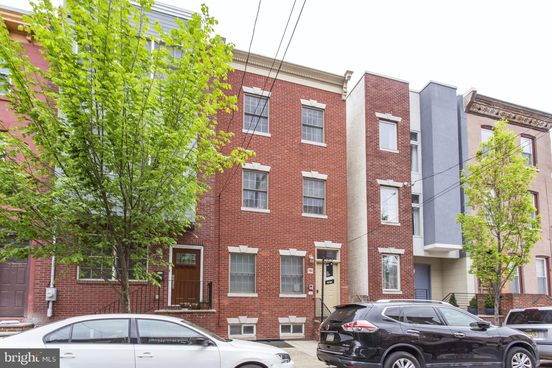 a front view of a building with trees