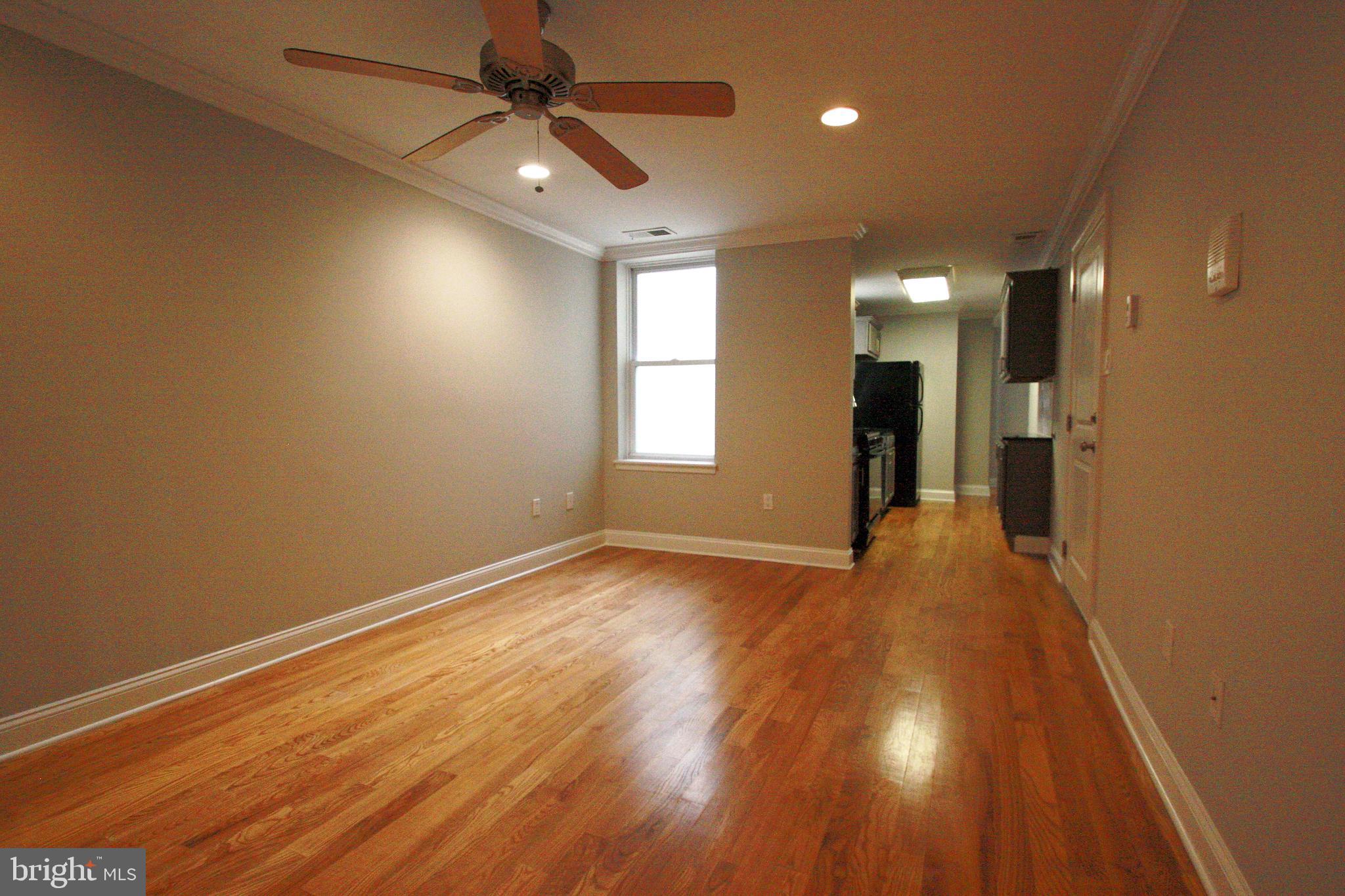 763 South 15th Street, Unit 2 Philadelphia, PA 19146 - Photo 2 of 12 an empty room with wooden floor and windows