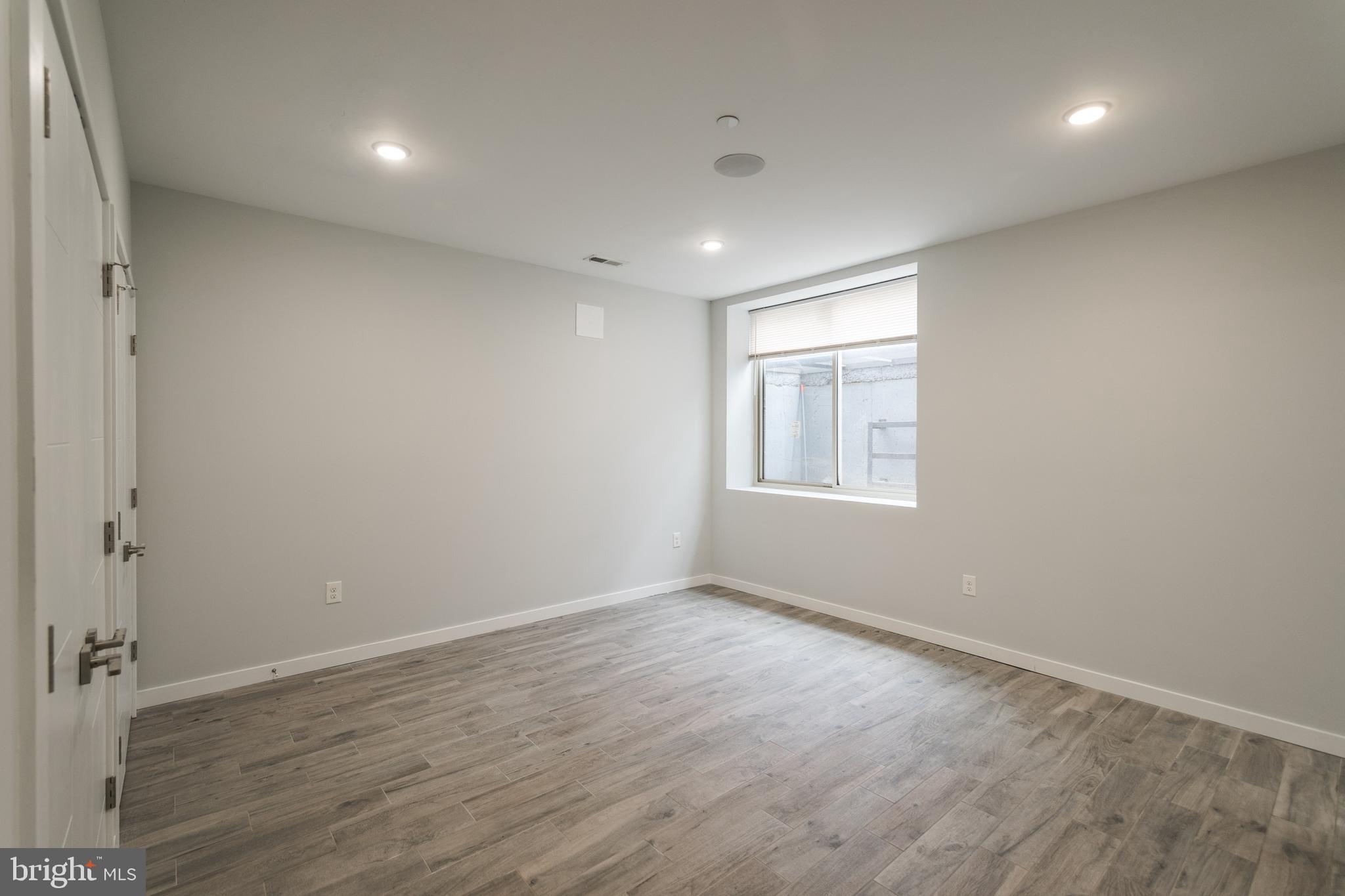 1524 North 8th Street, Unit 2 Philadelphia, PA 19122 - Photo 11 of 22 an empty room with wooden floor and windows