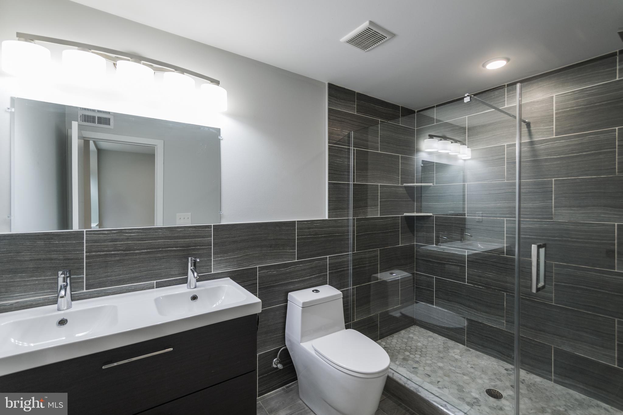 1524 North 8th Street, Unit 2 Philadelphia, PA 19122 - Photo 15 of 22 a bathroom with a toilet a sink and mirror