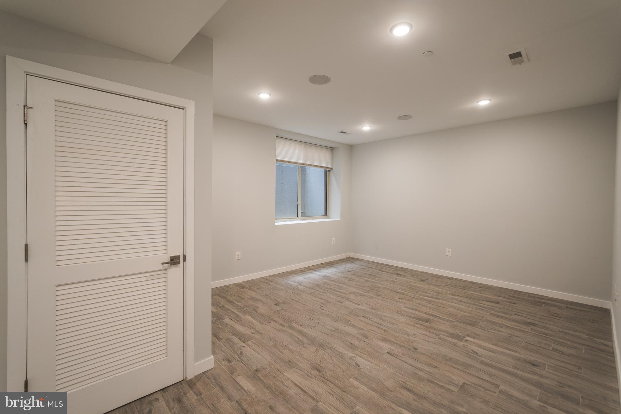 1524 North 8th Street, Unit 2 Philadelphia, PA 19122 - Photo 16 of 22 an empty room with wooden floor and windows