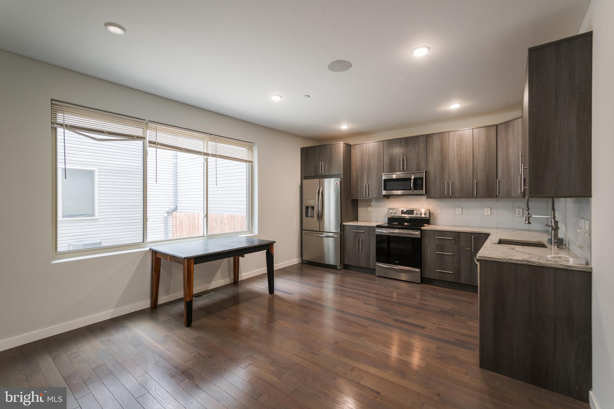 1524 North 8th Street, Unit 2 Philadelphia, PA 19122 - Photo 2 of 22 a kitchen with refrigerator cabinets and wooden floor