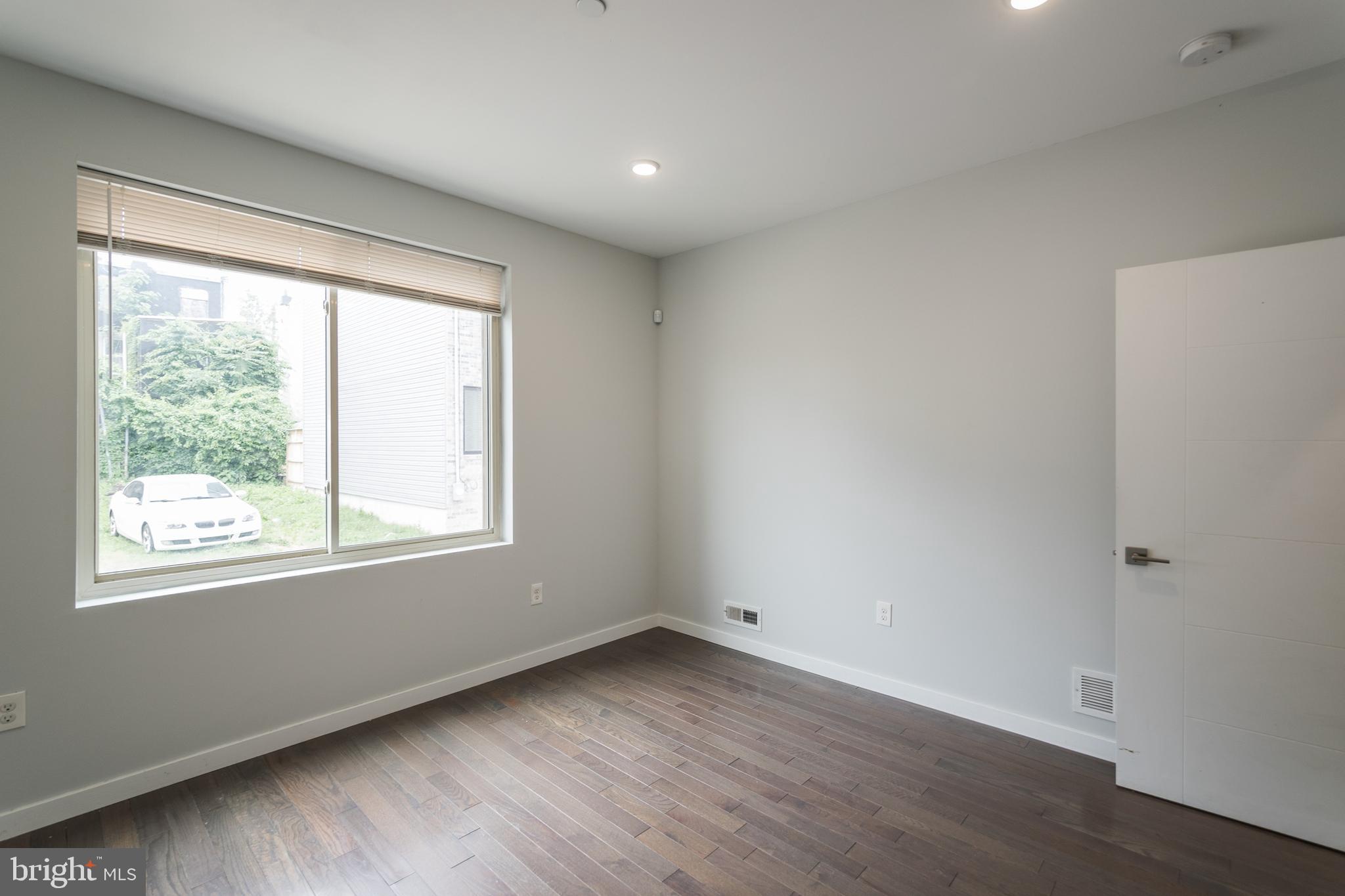 1524 North 8th Street, Unit 2 Philadelphia, PA 19122 - Photo 10 of 22 an empty room with wooden floor and windows