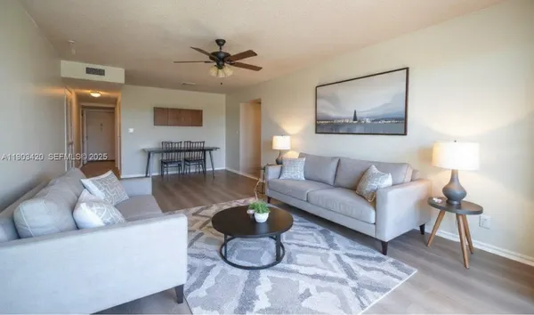 a living room with furniture and a wooden floor