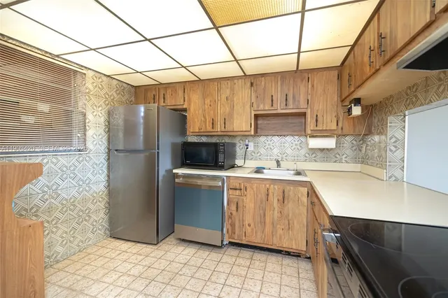 a kitchen with stainless steel appliances granite countertop a refrigerator and a stove