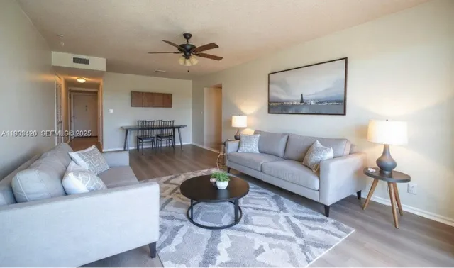 a living room with furniture and a wooden floor