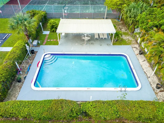 an aerial view of a house with swimming pool and outdoor space