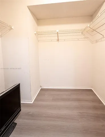 a view of a small space with wooden floor and a window