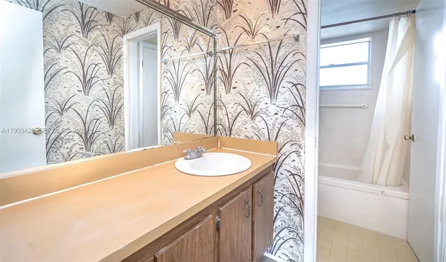 a bathroom with a granite countertop sink and a mirror