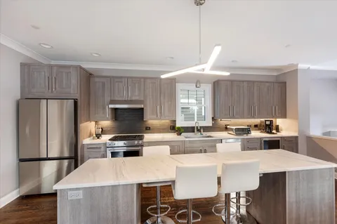 a large kitchen with stainless steel appliances a stove a sink dishwasher and cabinets with wooden floor