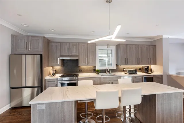 a large kitchen with stainless steel appliances a stove a sink dishwasher and cabinets with wooden floor