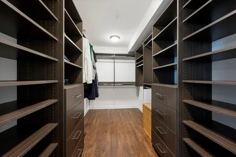 a bedroom with a large bed and a flat tv screen on dresser