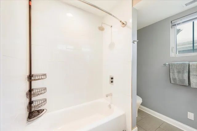 a living room with a couch and a potted plant