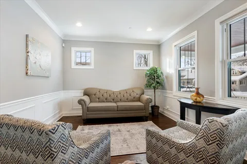 a living room with furniture wooden floor and a window
